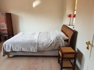 a bedroom with a bed and a dresser and a table at Meshka's Apartment in Vilnius