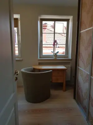 a room with a window and a chair and a table at Meshka's Apartment in Vilnius