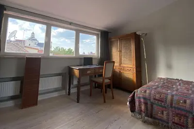 a bedroom with a desk and a bed and a window at Meshka's Apartment in Vilnius