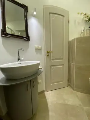 a bathroom with a sink and a mirror and a door at Meshka's Apartment in Vilnius