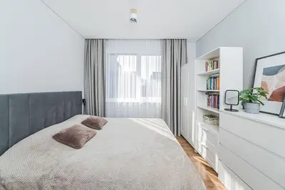 a white bedroom with a bed and a book shelf at Lovely Apartment with Private Terrace by URBAN RENT in Kaunas