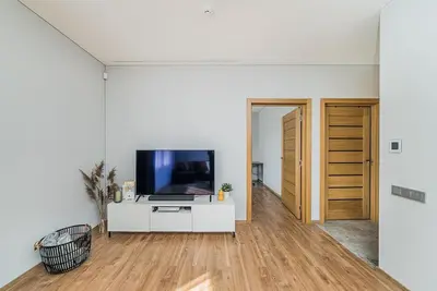 a living room with a flat screen tv on a white cabinet at Lovely Apartment with Private Terrace by URBAN RENT in Kaunas