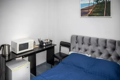 a bedroom with a bed and a desk with a microwave at Vilnius Centre Flat in Vilnius