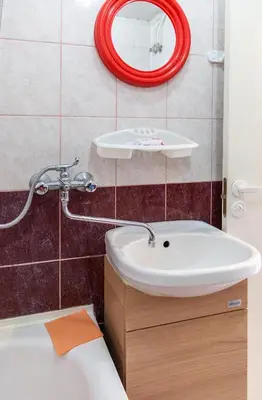 a bathroom with a white sink and a red mirror at Vilnius Centre Flat in Vilnius