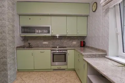 a kitchen with green cabinets and a sink at Poilsis prie Dineikos parko in Druskininkai