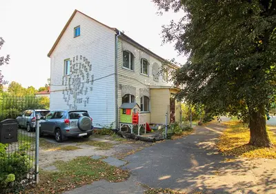 a house with a car parked in front of it at Authentic old studio house in Kaunas