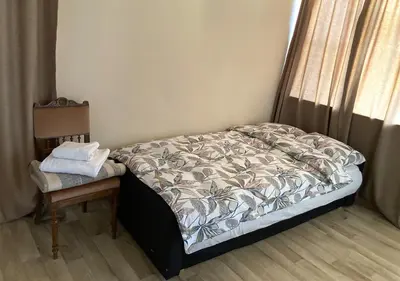 a small bedroom with a bed and a chair at Authentic old studio house in Kaunas