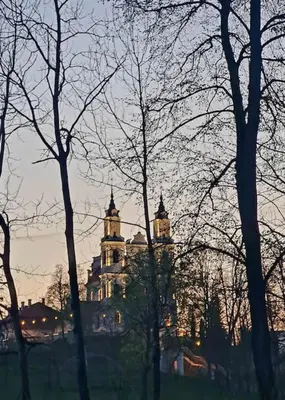 a building in the distance with trees in the foreground at Jeruzale Park view in Vilnius