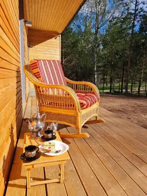 a wicker chair and a table on a porch at Miško Santorija in Ažuluokesa