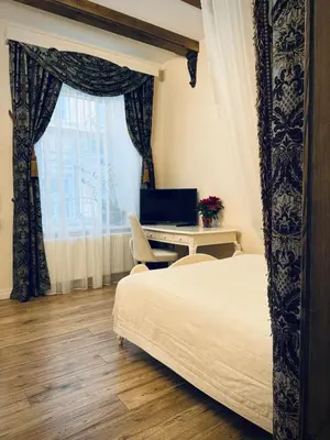 a bedroom with a bed and a desk with a computer at Noble Apartments in Vilnius