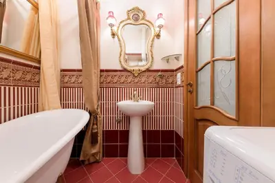 a bathroom with a tub and a sink and a mirror at Noble Apartments in Vilnius