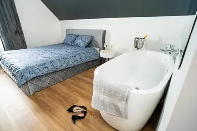 a bathroom with a bath tub and a bed at Fort63 Studio in Kaunas