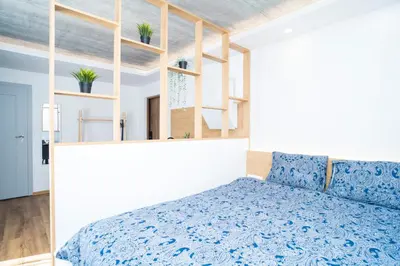 a bedroom with a blue bed and shelves at Fort63 Studio in Kaunas
