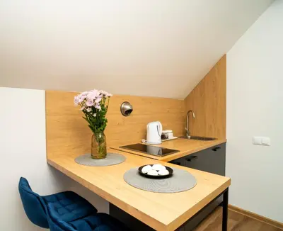 a kitchen with a table with a vase of flowers at Fort63 Studio in Kaunas