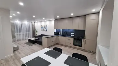 a kitchen and living room with a table and a couch at New apartment in the city in Šiauliai
