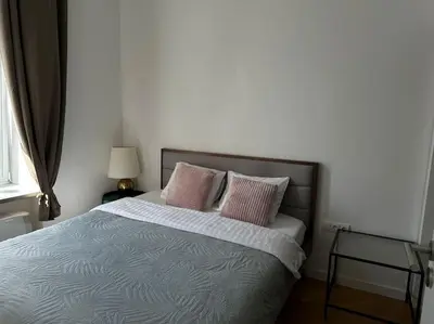 a bedroom with a bed with two pink pillows at M Loft3 in Kaunas