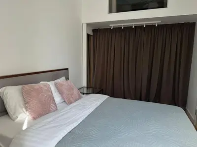 a bedroom with a bed with pink and white pillows at M Loft3 in Kaunas