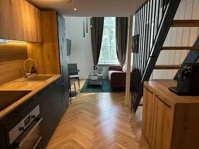 a kitchen with a staircase and a living room at M Loft3 in Kaunas