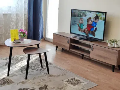 a living room with a tv and a table at Musninkų apartment near Akropolis in Vilnius