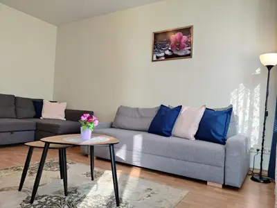 a living room with a couch and a table at Musninkų apartment near Akropolis in Vilnius
