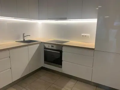 a white kitchen with a sink and a stove at Near Ozas in Vilnius