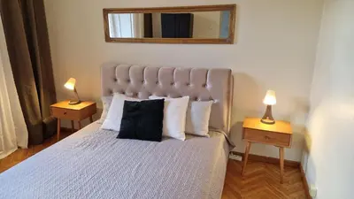 a bedroom with a large bed with two lamps on tables at TyzenXL Luxury Vilnius Apartments in Vilnius