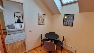 a room with a table and chairs and a couch at TyzenXL Luxury Vilnius Apartments in Vilnius