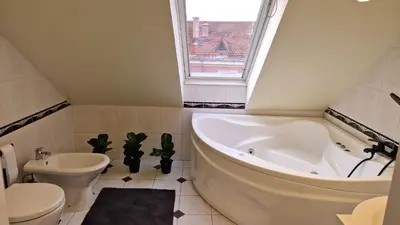 a bathroom with a tub and a toilet and a sink at TyzenXL Luxury Vilnius Apartments in Vilnius