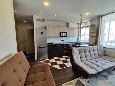 a living room with a couch and a kitchen at Apartments near BIG in Vilnius