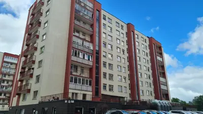 a tall apartment building with red and white at Apartments near BIG in Vilnius