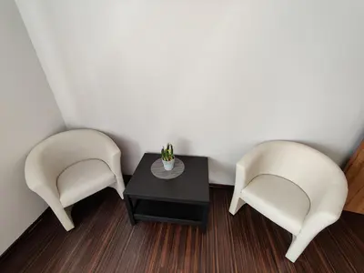 two white chairs and a table in a room at Apartments near BIG in Vilnius
