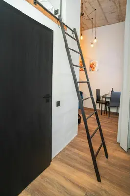 a ladder leading to a room with a door at Teeny Tiny Lofts in Center in Kaunas