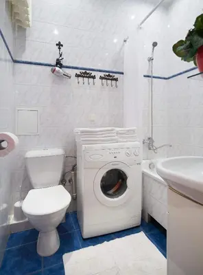 a bathroom with a toilet a sink and a washing machine at ReHouse- Didzioji 39 in Vilnius