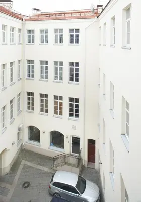 a car parked in a courtyard between two buildings at ReHouse- Didzioji 39 in Vilnius