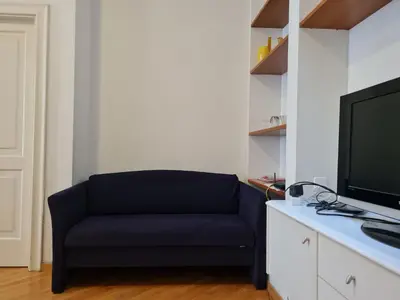 a living room with a blue couch and a tv at ReHouse- Didzioji 39 in Vilnius