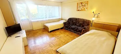 a room with a couch and a chair and a bed at Hostel 4 in Šiauliai