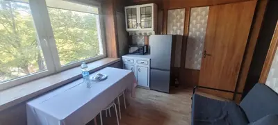 a kitchen with a white table and a refrigerator at Hostel 4 in Šiauliai
