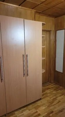 a large closet with wooden cabinets in a room at Hostel 4 in Šiauliai