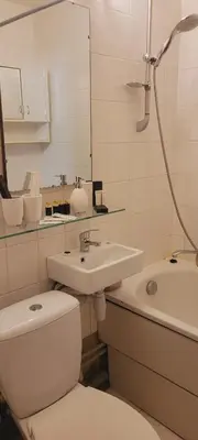 a white bathroom with a toilet and a sink at Hostel 4 in Šiauliai
