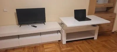 a white desk with a laptop and a tv on it at Hostel 4 in Šiauliai