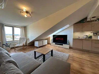 a living room with a couch and a tv at Apartments in the old town with an impressive view in Vilnius
