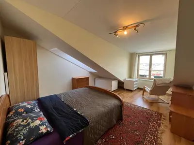 a attic bedroom with a bed and a staircase at Apartments in the old town with an impressive view in Vilnius