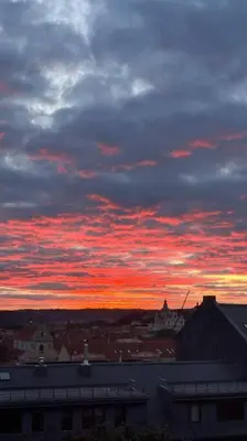 a cloudy sky with a sunset in a city at Apartments in the old town with an impressive view in Vilnius