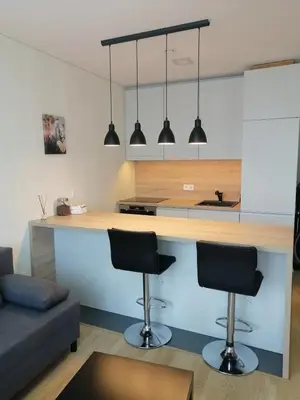 a kitchen with two bar stools in a living room at B23 Apartments in Vilnius