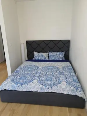 a bed with a blue and white comforter and pillows at B23 Apartments in Vilnius