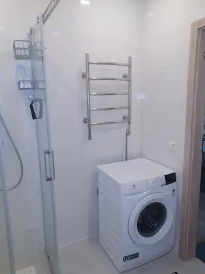 a washing machine in a bathroom with a shower at B23 Apartments in Vilnius