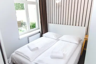 a white bed in a room with a window at The House in Druskininkai