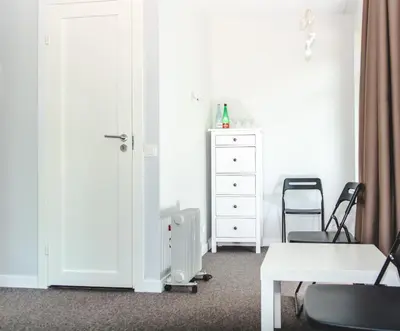 a room with a door and a chair and a dresser at The House in Druskininkai