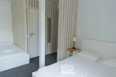 a bedroom with two white beds and a mirror at The House in Druskininkai