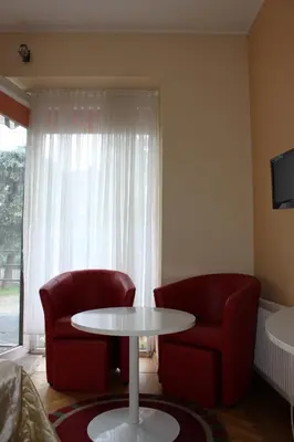 a living room with two red chairs and a table at Jauku Erdvu Šilta in Kaunas